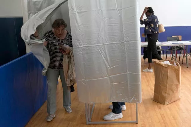 A woman exits a voting booth in Paris, France