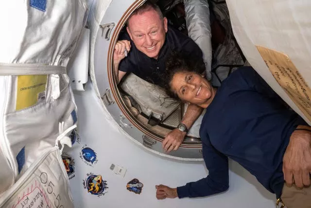 Boeing Crew Flight Test astronauts Butch Wilmore, left, and Suni Williams pose for a portrait inside the vestibule between the forward port on the International Space Station’s Harmony module and Boeing’s Starliner spacecraft on June 13 2024 