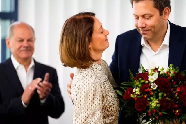 SPD co-chairman Lars Klingbeil, right, gives flowers to top candidate Katarina Barley, centre 