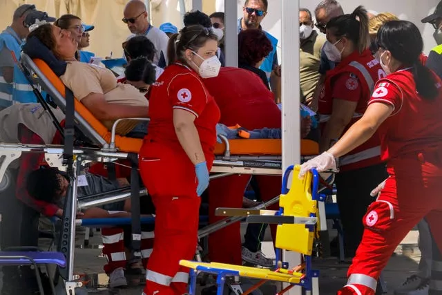 Some of the 11 migrants saved from the sea after their sailboat sank in the Mediterranean Sea between Italy and Greece 