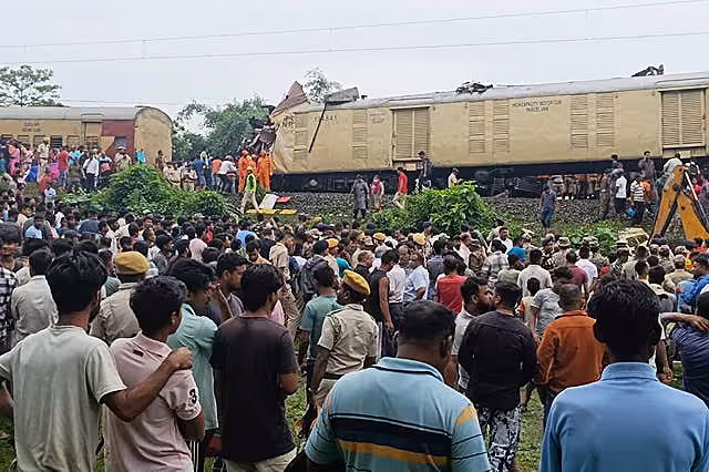 Onlookers watch as rescuers work after a cargo train rammed into Kanchanjunga Express, a passenger train, near New Jalpaiguri station, West Bengal state, India 