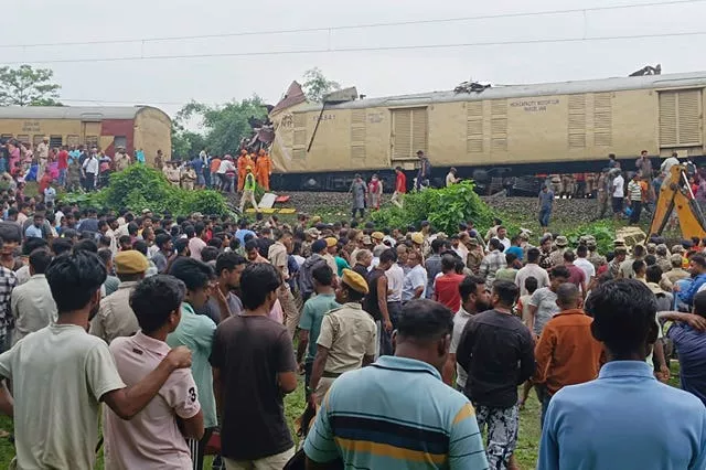 Onlookers watch as rescuers work after a cargo train rammed into Kanchanjunga Express, a passenger train, near New Jalpaiguri station, West Bengal state, India 