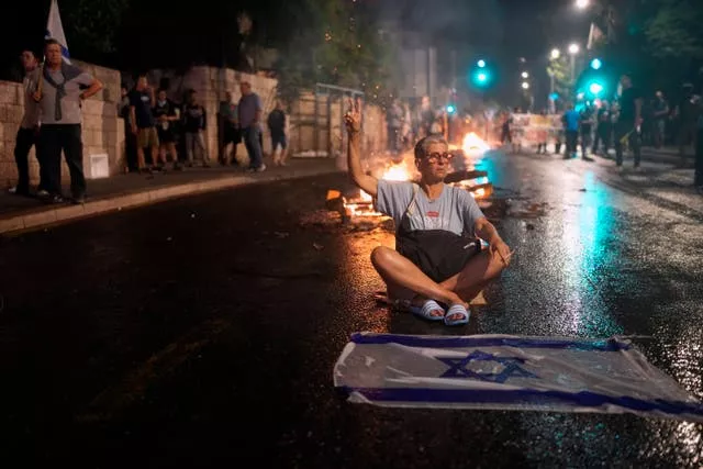 A demonstrator sits on the street in Jerusalem during a protest against Israeli Prime Minister Benjamin Netanyahu’s government