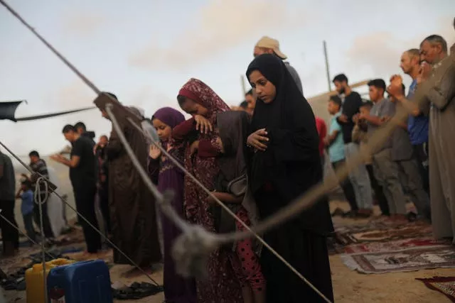 Palestinians displaced by the Israeli air and ground offensive on the Gaza Strip offer Eid al-Adha prayers at a makeshift tent camp Khan Younis, Gaza 