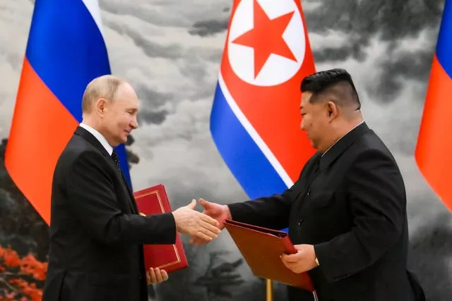 Russian President Vladimir Putin and North Korea’s leader Kim Jong Un exchanging documents