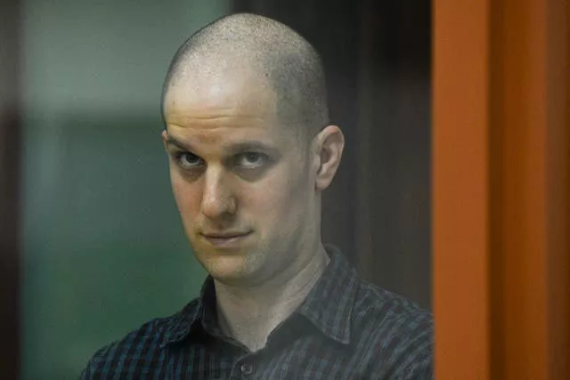 Wall Street Journal reporter Evan Gershkovich stands in a glass cage in a courtroom in Yekaterinburg 