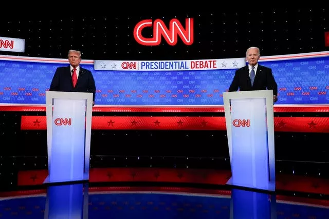 President Joe Biden, right, and Republican presidential candidate former president Donald Trump, left, stand on stage during a break in a televised presidential debate