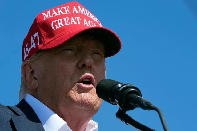 Donald Trump wearing a MAGA cap speaks at a campaign rally in Virginia