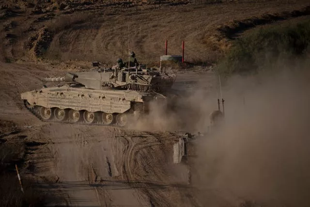 A tank moves through a dusty landscape