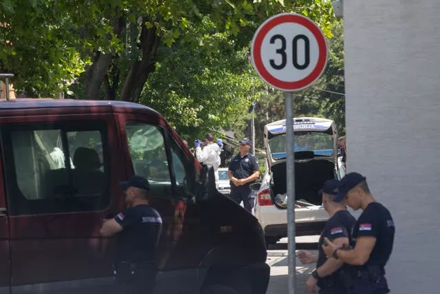 Police officers work at a crime scene close to the Israeli embassy in Belgrade