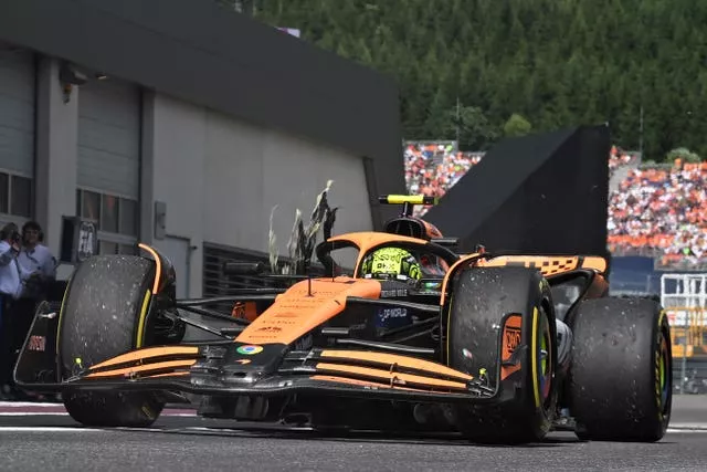 McLaren's Lando Norris arrives in the pits with a damaged right rear tyre during the Austrian Grand Prix
