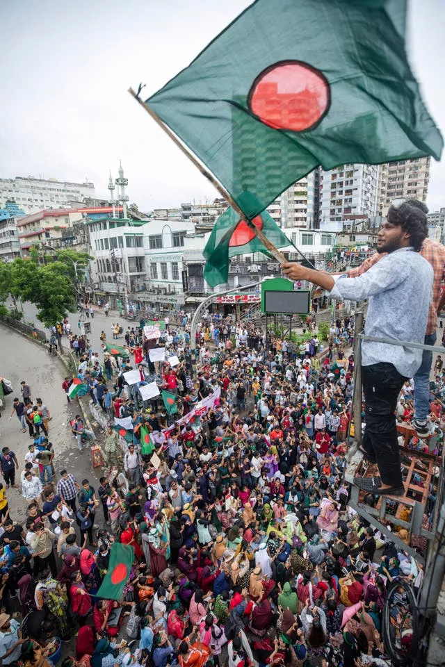 یک فعال پرچم بنگلادش را در راهپیمایی اعتراضی به اهتزاز در می آورد