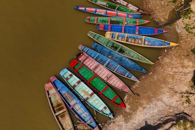 Brightly coloured boats on a drying river