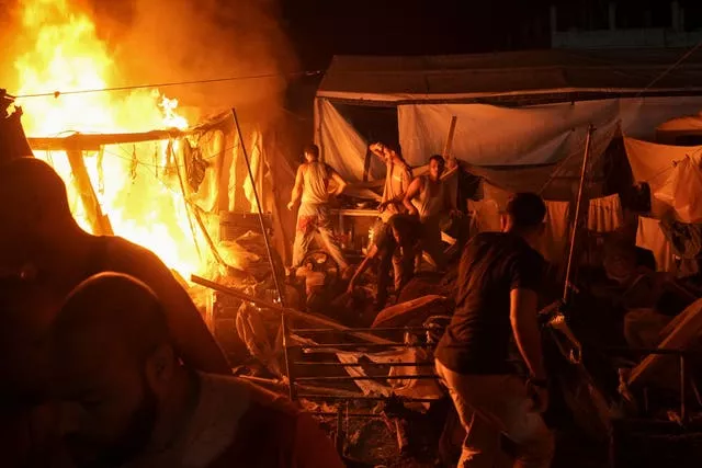 Palestinians react to fire from an Israeli strike that hit a tent area in the courtyard of Al Aqsa Martyrs hospital in Deir al Balah, Gaza Strip,