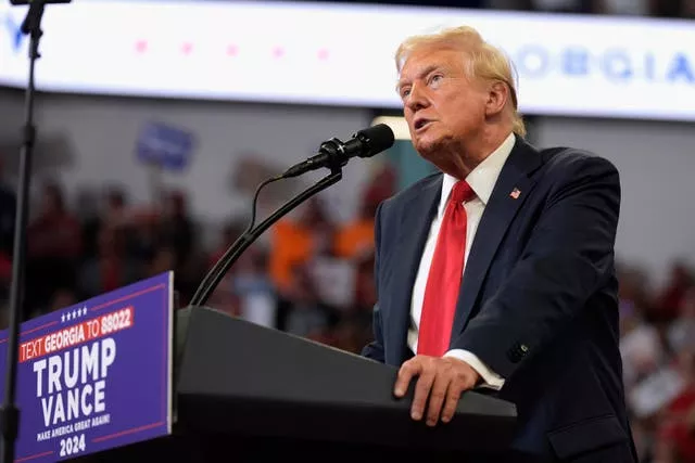 Donald Trump speaking at a campaign lectern