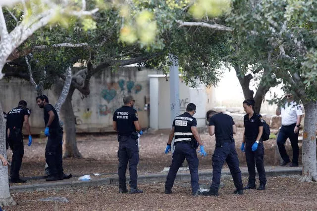 Israeli police officers inspecting ground and taking photos