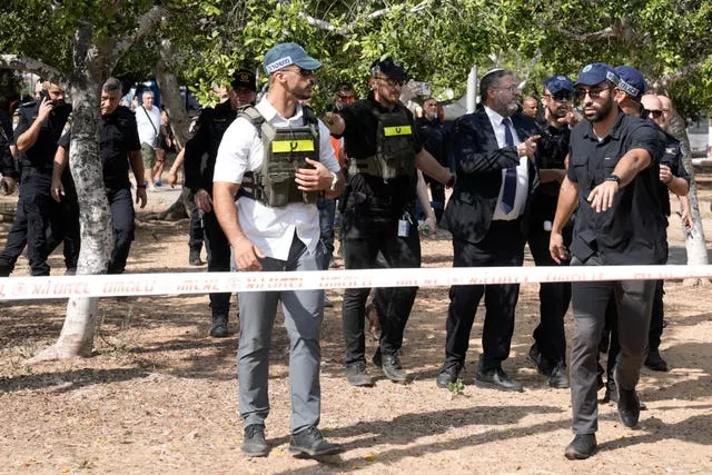 Israeli officials walking behind crime scene tape