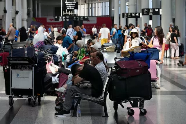 Personas con maletas esperando en un aeropuerto.