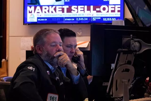 Two men under a screen reading Market Sell-Off