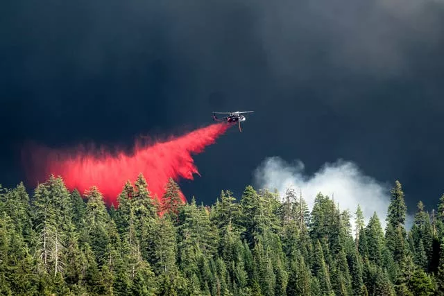 A helicopter drops fire retardant 