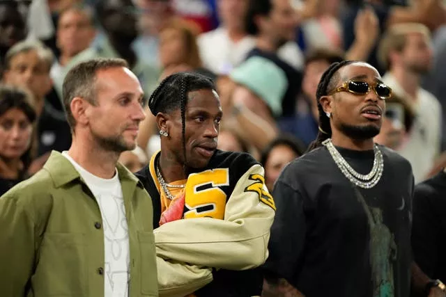 Travis Scott watches a basketball match