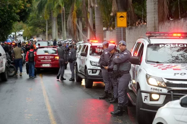 Police stand along the street leading to the gated community where a plane crashed in Vinhedo, Sao Paulo state, Brazil 