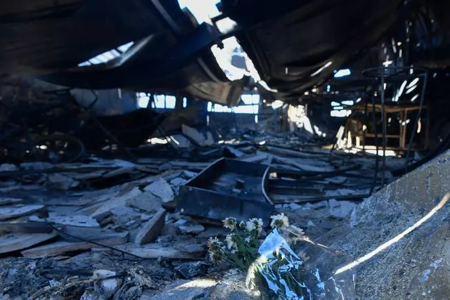 Flowers placed inside a damaged factory where one person was found dead, in the Chalandri suburb of Athens 