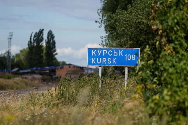 A blue road sign says Kursk 108 km