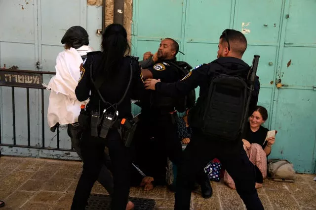 Israeli police prevent a Jewish worshipper from breaking through the police barrier to enter Jerusalem’s most sensitive holy site, which Jews revere the site as the Temple Mount