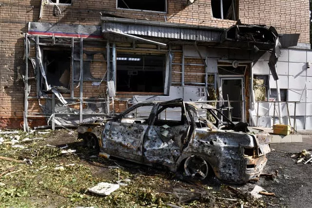 A burned car in front of an apartment building damaged after shelling by the Ukrainian side in Kursk, Russia