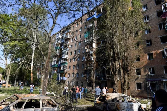 La gente se reúne en un edificio de apartamentos dañado tras el bombardeo ucraniano en Kursk, Rusia (Associated Press)