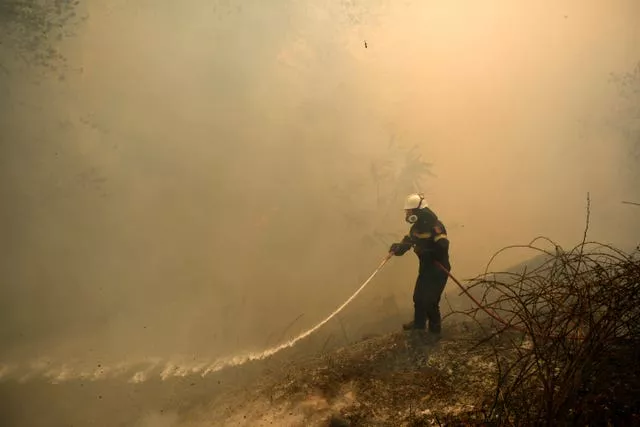 Un bombero intenta apagar un incendio en el norte de Atenas