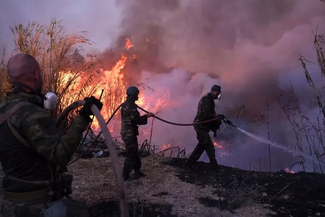 Volunteers try to extinguish the fire in northern Athens 