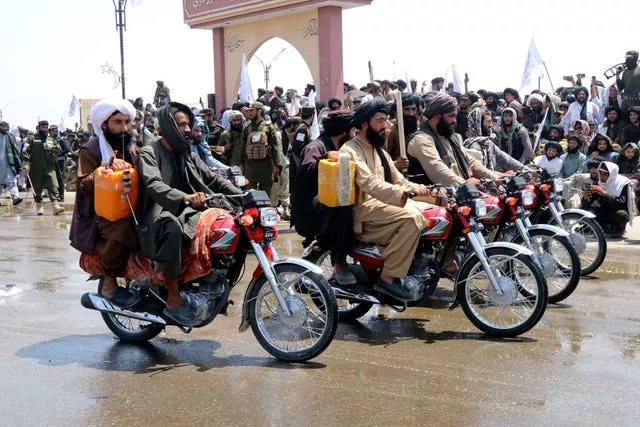 Afghan men on motorbikes parade in the street