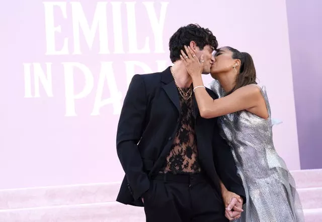 Ashley Park and Paul Forman kiss on the lilac carpet