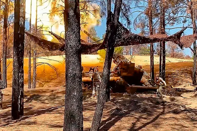 Russian soldiers fire from a 203-mm self-propelled gun 2S7 'Pion' towards Ukrainian positions in an undisclosed location in Ukraine