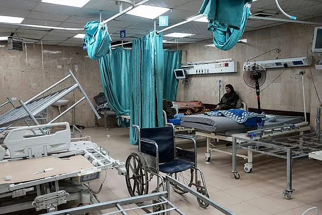 A woman sits on a bed in a room of the Al-Aqsa Martyrs hospital in Deir al Balah