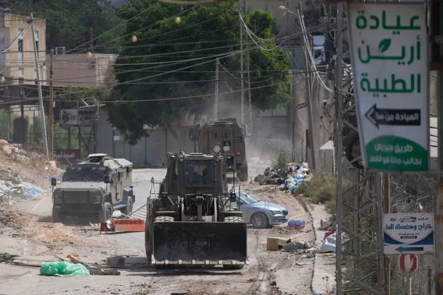 A bulldozer from the Israeli forces moves on a street during a military operation in the West Bank refugee camp of Al-Faraa