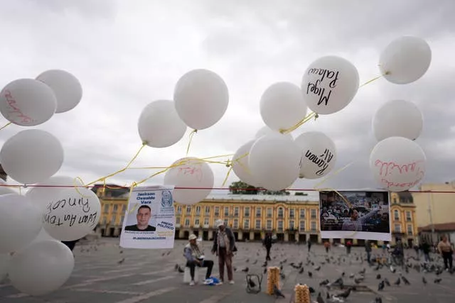 Photos and balloons representing people detained by Venezuelan security forces after Venezuela’s presidential election hang at Bolivar square in Bogota, Colombia