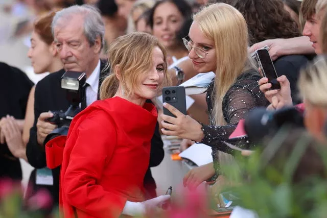 Isabelle Huppert poses for a photos with fan