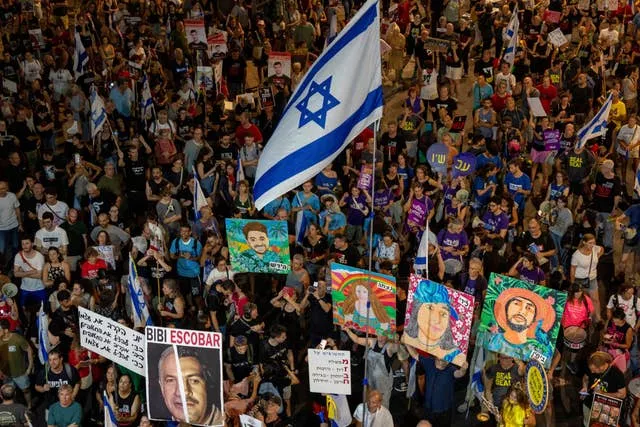 Huge crowd of people, holding Israeli crowds and artwork representing missing hostages