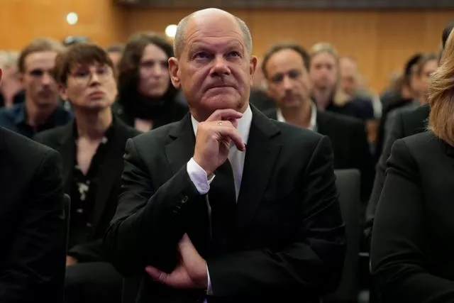 Olaf Scholz listens as he sits in an audience