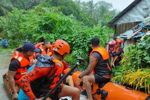 Rescuers take people to safety on a boat