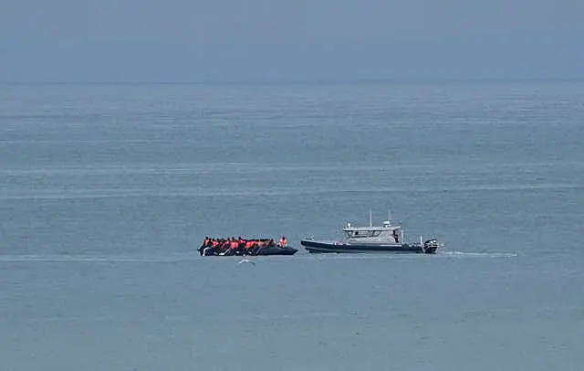 A boat thought to be with migrants is escorted by a vessel from the French Gendarmerie Nationale