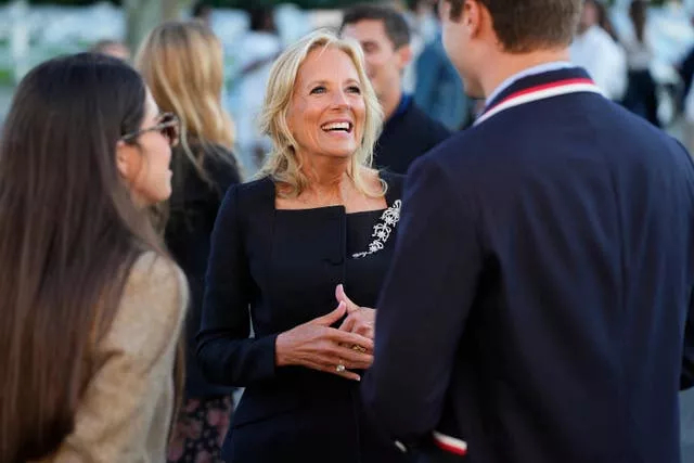 Jill Biden talks to Ralph Lauren models in black square necked pant suit