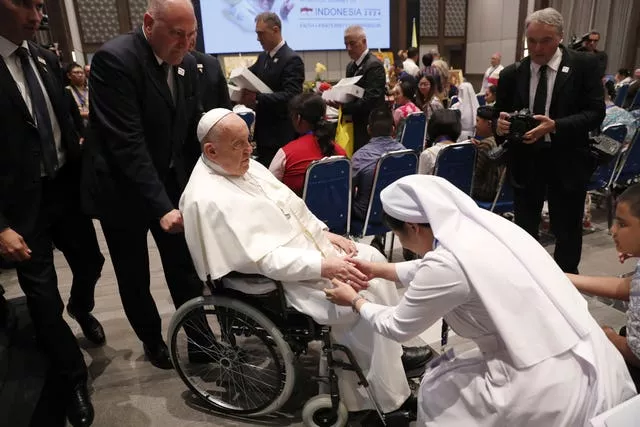 Pope Francis is greeted by a Catholic nun during a meeting with beneficiaries from charitable organisations at the Indonesian Bishops’ Conference Headquarters 