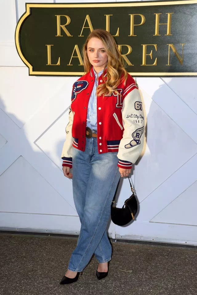 Joey King wears red and white baseball jacket and jeans 