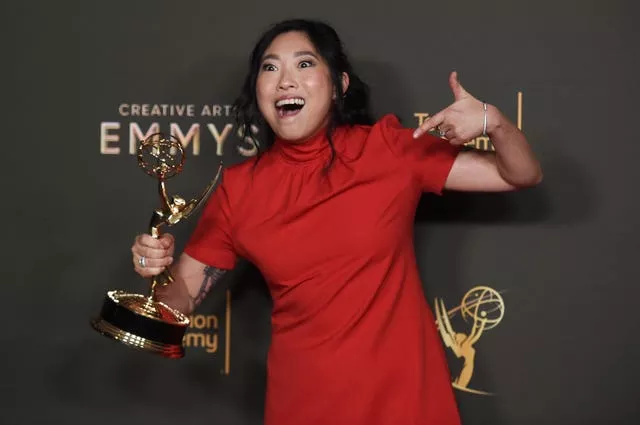 Awkwafina poses with the award for outstanding television movie for Quiz Lady 