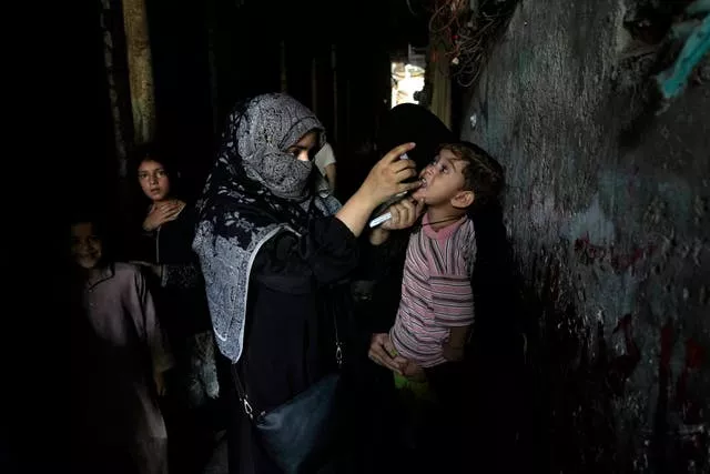 A health worker administers a polio vaccine to a child in a downtown area of Lahore