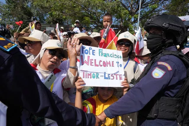 A child holds a welcome sign for Pope Francis in Dili, East Timor 